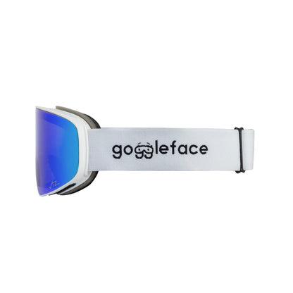 Side view of a pair of Goggleface Straight Line snow goggles with reflective blue lenses and a white strap. The strap features the brand name "Goggleface" in black text along with a small goggle icon. The frame is white with black accents, designed for performance on those straight-line descents.